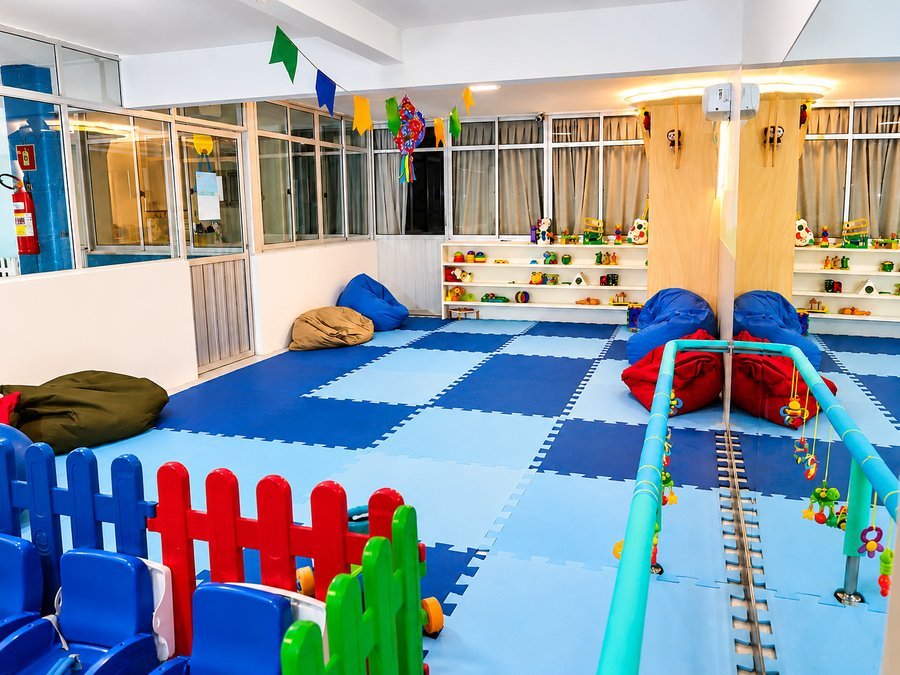 Espaço cercado do berçário com tatames coloridos